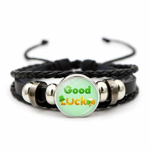 Macro shot of multi-layer leather bracelet featuring green Good Luck glass charm