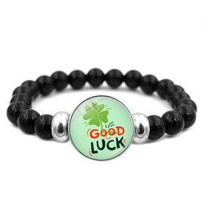 Vista macro del bracciale con perline, ciondolo a quadrifoglio e dettaglio Good Luck