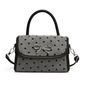 Chic grey underarm bag with black heart patterns and a silver metallic bow decoration