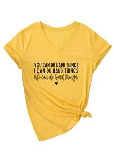 Detail of V-neck yellow T-shirt with 'YOU CAN DO HARD THINGS' text and bottom hem knot