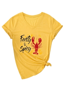 Détail d'un t-shirt jaune à col en V avec imprimé homard et ourlet noué tendance