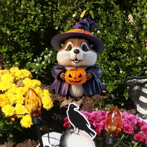 Detail of chipmunk wizard stake with orange pumpkin lamp in garden foliage