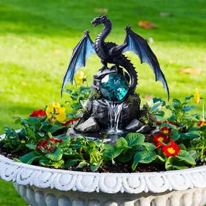 Garden dragon statue with blue wings and sapphire gem on a stone base in a flower pot