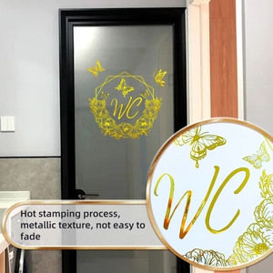 Close-up of golden floral WC door sticker with metallic hot stamping on a glass panel