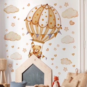 Detail of hand-painted bear and hot air balloon wall stickers in a cozy nursery setup