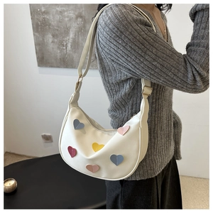 Sac à bandoulière en demi-lune blanc orné de patchs en forme de cœurs colorés