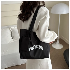 Détail du sac cabas en toile noire avec inscription FASHION et petite pochette amovible