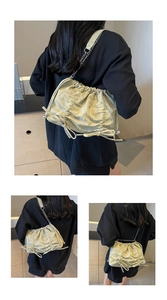 Close-up of pleated light green tote bag with silver chain strap worn by a model