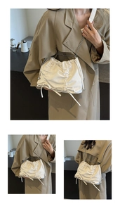 Detail of white pleated tote bag featuring drawstring closure and silver chain strap