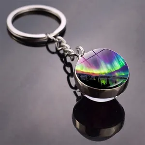 Macro view of Aurora Borealis glass cabochon keychain with vibrant purple and green colors