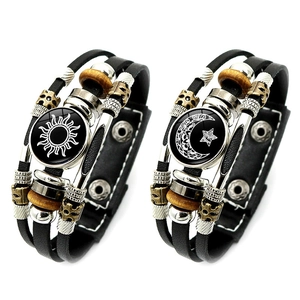 Detailed close-up of luminous sun and moon charms on braided leather bracelets