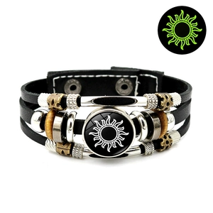 Detail view of multi-layer leather sun charm bracelet with green glow-in-the-dark effect