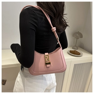 Detailed view of a pink leather hobo bag with gold geometric buckle and knotted shoulder strap