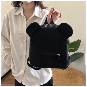 Détail d'un mini sac à dos en velours côtelé noir avec oreilles d'ours et fermetures argentées