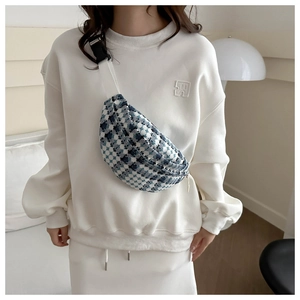 Detail of blue and white plaid tweed crossbody bag shown on a model for size and style