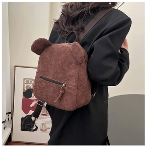 Détail d'un sac à dos en velours côtelé marron avec oreilles d'ours sur un mannequin