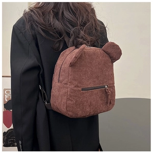 Détail du sac à dos en velours côtelé marron avec oreilles d'ours et texture rayée