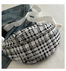 Detailed view of black and white houndstooth fanny pack with white nylon strap and zipper