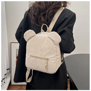 Détail du sac à dos beige en velours côtelé avec oreilles d'ours 3D et poche avant zippée