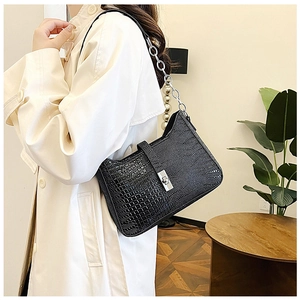 Detail of black crocodile texture shoulder bag with stylish silver chunky chain strap