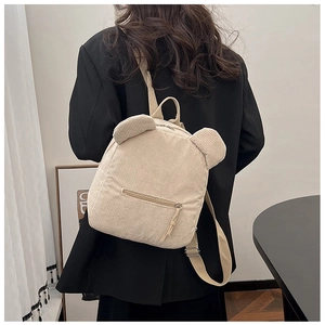 Détail du sac à dos beige en velours côtelé avec oreilles d'ours porté par un modèle