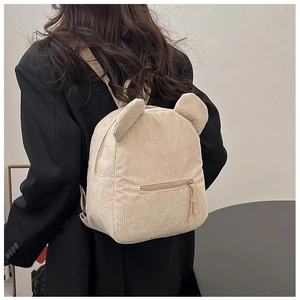 Détail d'un mini sac à dos en velours côtelé blanc cassé avec oreilles d'animaux