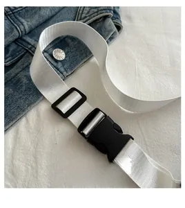Detail of wide white fabric shoulder strap with black plastic buckle and adjustable slider