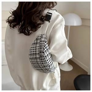 Detail of adjustable strap and black-white checkered texture on a stylish waist bag