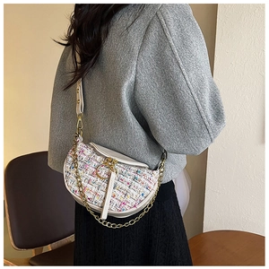 Detail of tweed and leather patchwork waist bag with gold ring zipper and chain strap