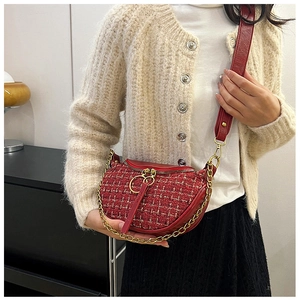 Detail of burgundy tweed crescent bag with gold chain and dual metal ring zippers