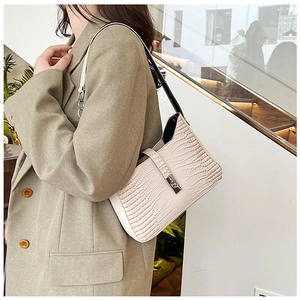 Detail of off-white crocodile pattern underarm bag with silver buckle on suit model