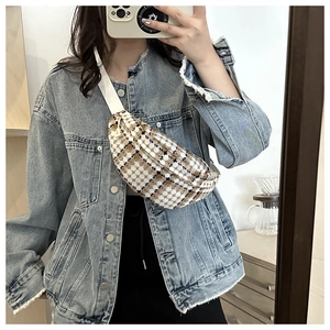 Detail van de geruite crossbody tas gedragen over een spijkerjasje in een spiegelselfie