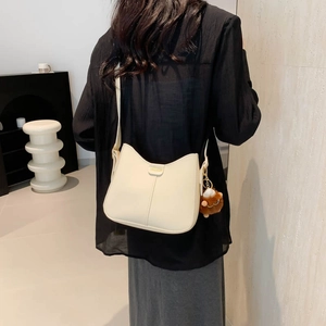 Chic beige crossbody bucket bag with golden fashion plate and cute brown fur charm