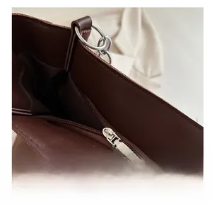 Detail view showing smooth inner zipper pocket of the dark brown tote bag interior