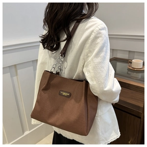 Dettaglio della borsa tote in pelle PU marrone con tracolla a catena metallica