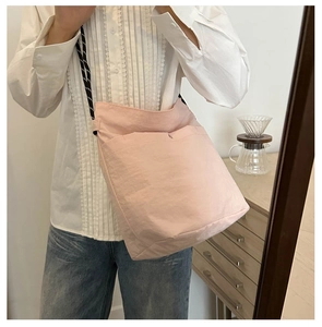 Detail of pink nylon crossbody bag featuring stylish braided rope shoulder strap for women