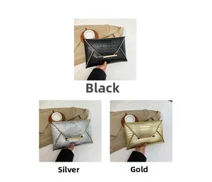 Detail view of crocodile embossed envelope clutch bags in black, silver, and gold finish