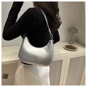Vue détaillée du sac hobo argenté avec un nœud chic et une finition métallique
