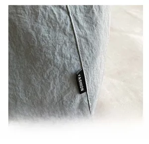 Détail du tissu en nylon bleu clair avec une étiquette Fashion noire sur la couture