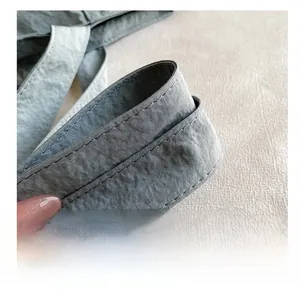 Gros plan détaillé de la bandoulière en nylon gris avec coutures doubles renforcées