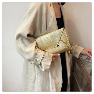 Detail shot of golden crocodile texture and metal trim on this elegant envelope clutch