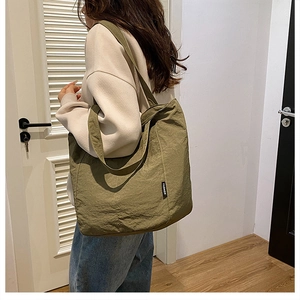 Sac fourre-tout minimaliste en toile vert olive avec étiquette mode porté par un mannequin