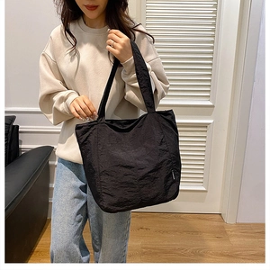 Detail der minimalistischen schwarzen Nylontasche mit Fashion-Label und Texturstoff