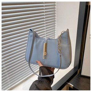 Détail du sac bandoulière bleu clair avec fermoir en métal doré et chaîne dorée