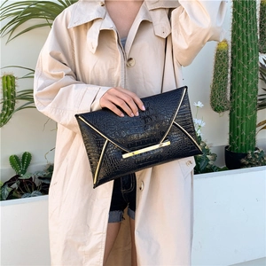 Chic black crocodile embossed envelope clutch with gold trim for formal or casual wear