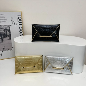 Vintage textured envelope clutch bag in black, gold, and silver crocodile pattern