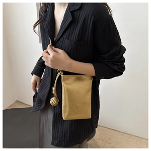 Détail d'un mini sac bandoulière doré métallisé avec bandoulière en corde nouée