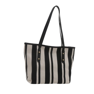 Minimalist black and white striped tote bag with leather handles and gold rivets