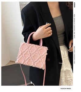 Side view of pink denim handbag with frayed diamond quilting and leather strap