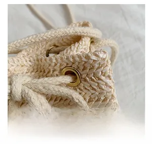 Detail of premium golden metal eyelet and textured woven drawstring on cream bag